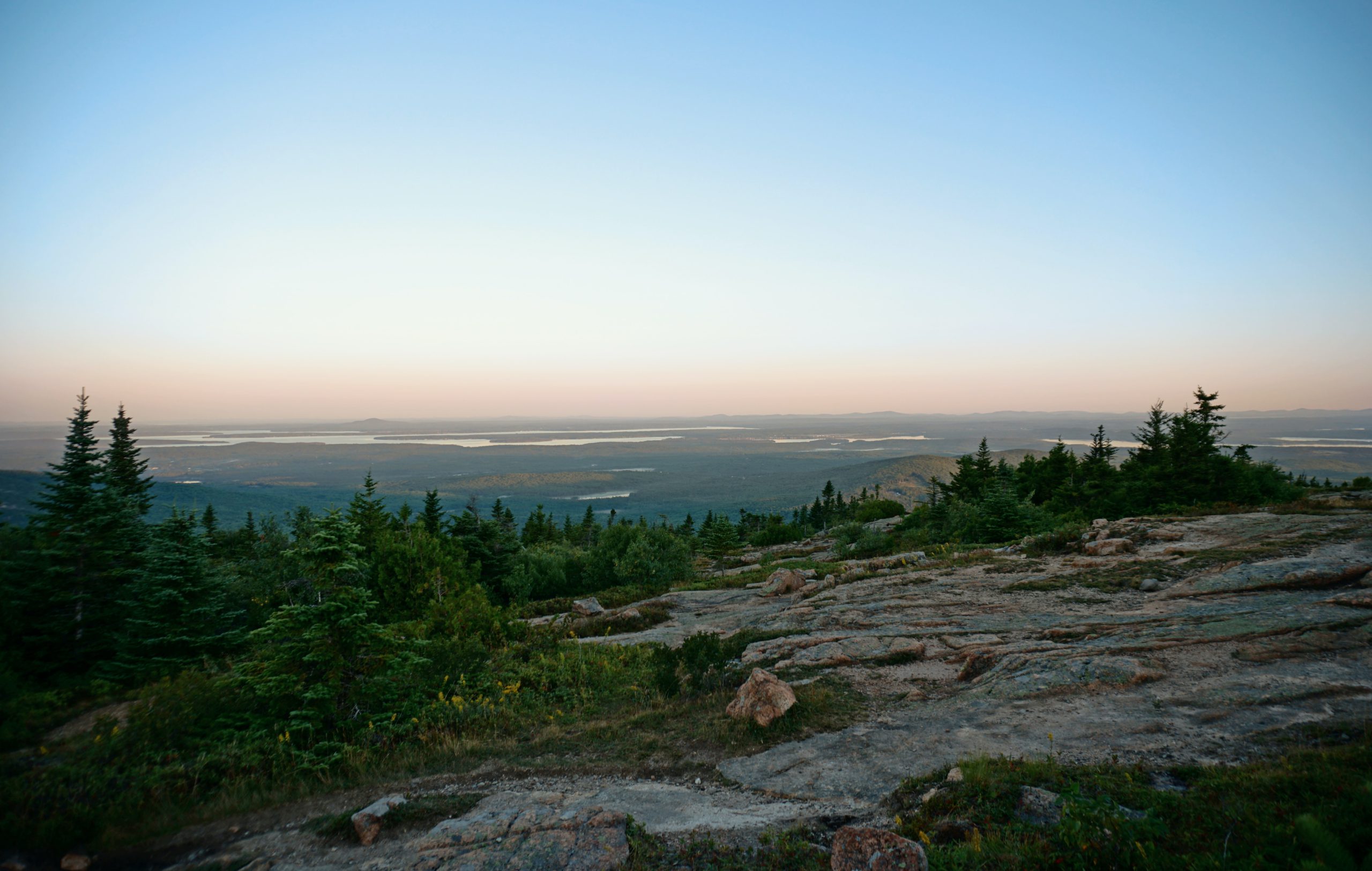 The beautiful view of Acadia National Park with clear skies and its forest surrounding.