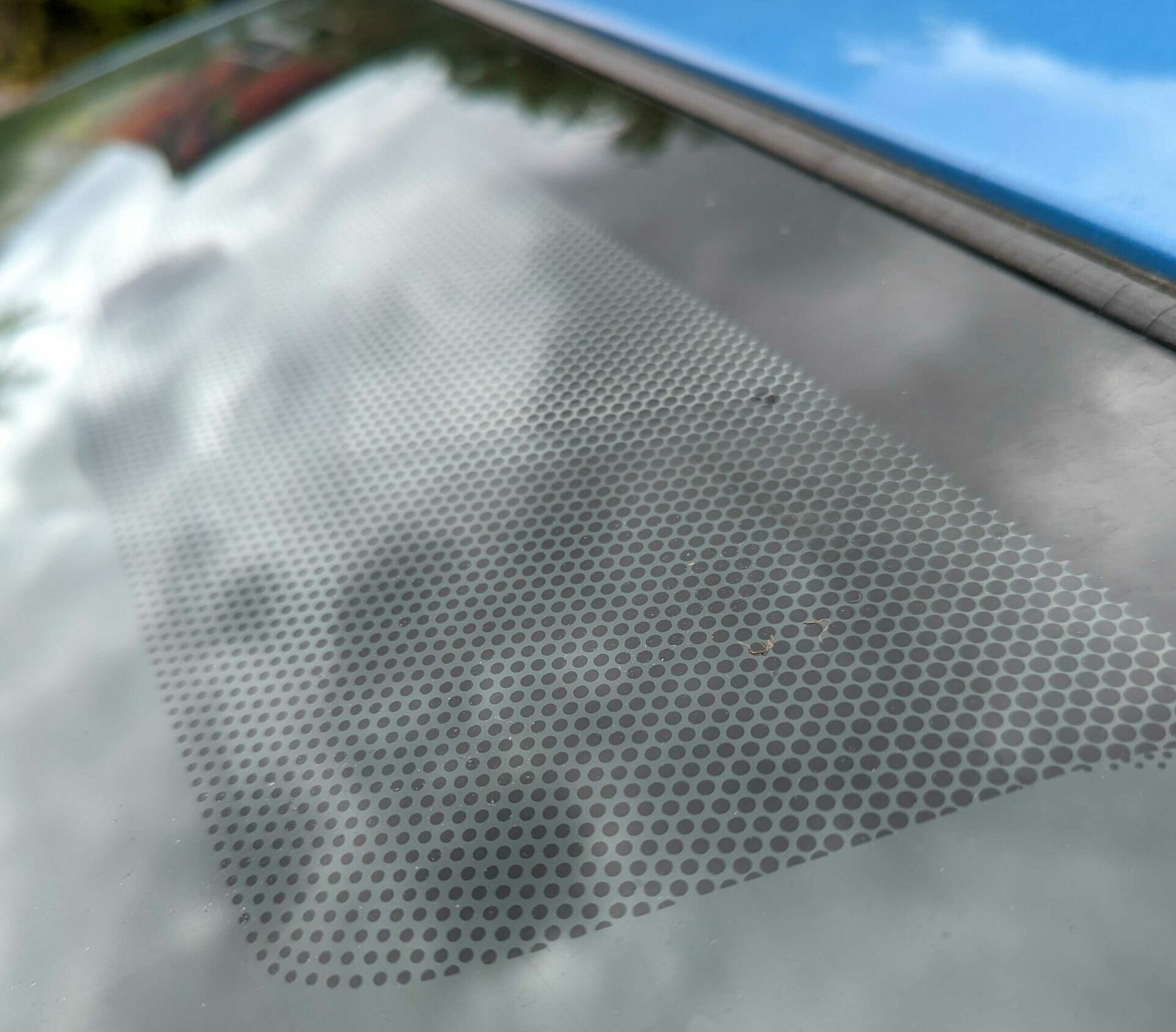 Frit dots on car's windshield, blue car