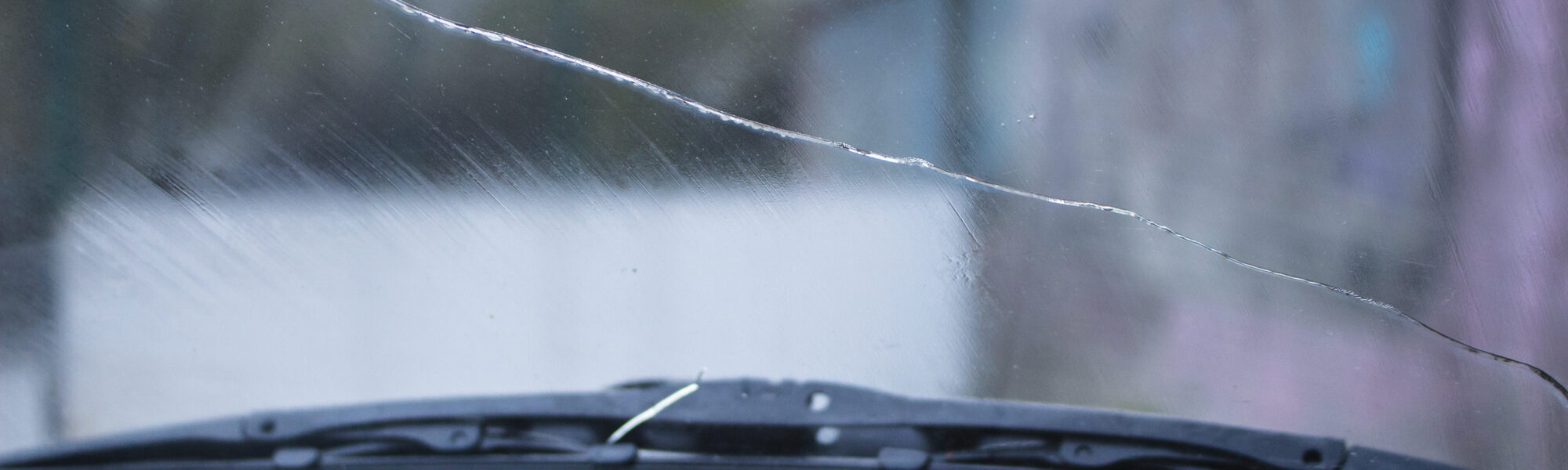 Long extended crack on a Camry windshield, view from inside, rainy weather