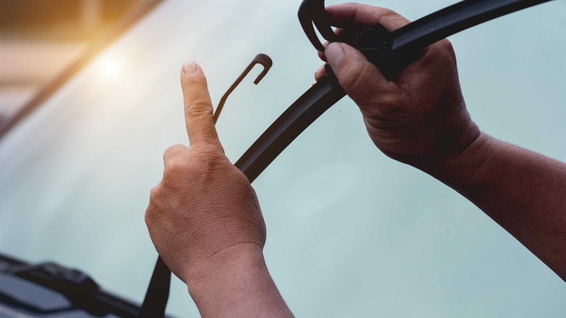 Person in replacing wiper blade on a vehicle